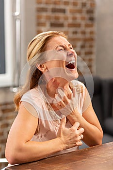 Mature sick woman screaming because of pain and rash