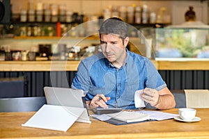 Mature small business owner calculating finance bills of activity, Entrepreneur using laptop and calculator to work