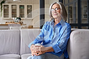 Mature smiling 60s woman portrait at home looking at camera.