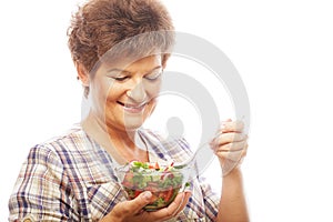 Mature smiling woman eating salad