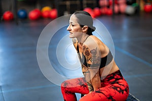 Mature sportive woman resting sitting on a gym