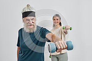 Mature sports couple doing exercise with dumbbells