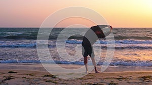 Mature sportsman warming up and stretching at sunrise over the sea