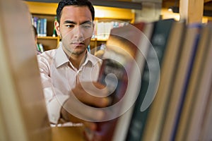 Mature student selecting book from shelf in the library