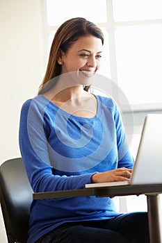 Mature student using computer in class