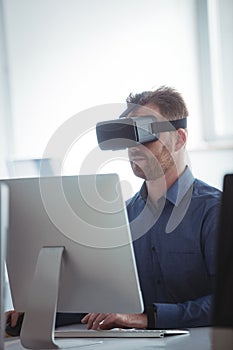 Mature student in virtual reality headset using computer