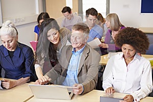 Mature Students In Further Education Class With Teacher