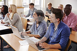 Mature Students Sitting At Desks In Adult Education Class