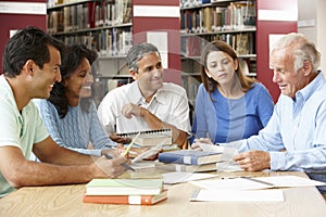 Mature students working in library