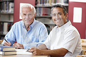 Mature students working in library