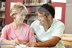 Mature students working in library