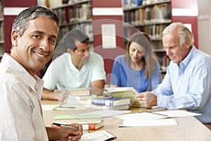 Mature students working in library