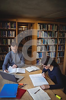 Mature students working together in college library