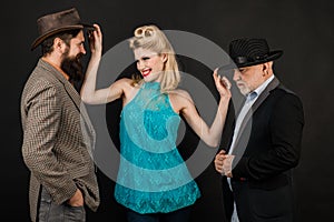 Mature stylish senior man and berded guy with funny yong woman wear retro hat, modern and hipster or vintage style for