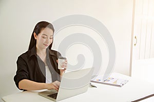 Mature successful business woman looking at laptop while at home in office work space