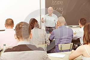 Mature teacher standing in front of students
