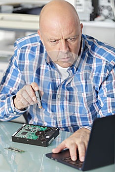 Mature technician with broken hard drive