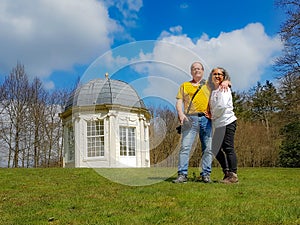 Mature tourist couple, a Mexican woman and a Dutch man with the Tea dome or Theekoepel or Gloriette in the background