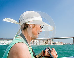 Mature tourist woman sails on boat in Venice