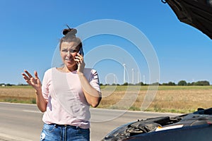 Mature upset woman driver calling on mobile phone for help, female near broken car