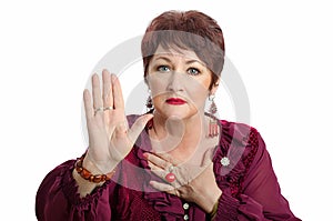 Mature wary woman posing with raised right hand