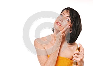 Mature well groomed woman with bottle of perfumes