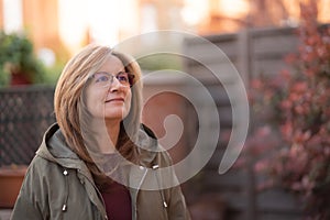 Mature white woman with blond hair in a happy and relaxed attitude on the outside