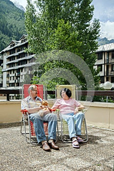 The mature wife and husband and their cat rest on lounges