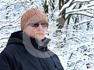 A mature woman against the background of snowy trees