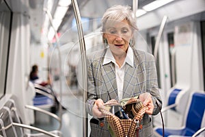 Mature woman amazed by theft from her bag in subway car