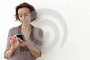 Mature woman annoyed with her phone