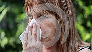 Mature woman blowing her nose