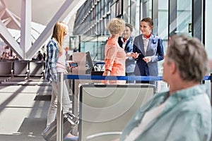 Mature woman on board giving her passport and boarding pass in airport