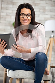 mature woman browsing internet with digital tablet