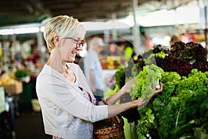 Mature woman buying vegetables at farmers market