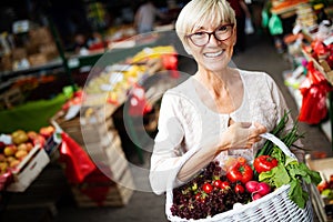 Mature woman buying vegetables at farmers market