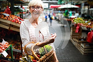 Mature woman buying vegetables at farmers market