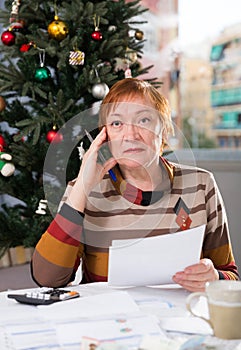 Mature woman calculates utility costs in the new year
