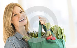 Mature Woman Carrying Shopping Bag Full Of Vegetables