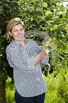 Mature woman check apple trees in her orchard