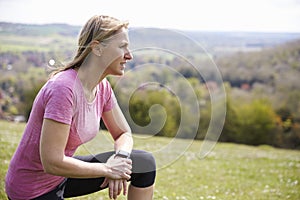 Mature Woman Checking Activity Tracker Whilst On Run