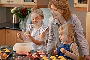 Mature woman, children and smile for baking in retirement for family, fun and bonding at home. Happy, female pensioner