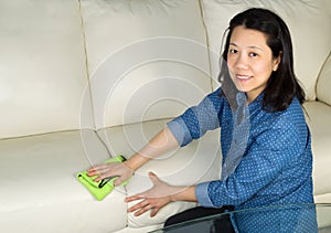 Mature woman cleaning Sofa with Microfiber Rag