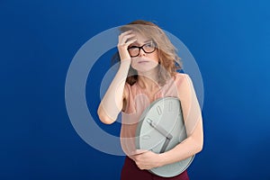 Mature woman with clock on color background. Time management concept