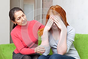 Mature woman comforts crying daughter