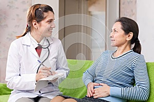 Mature woman complaining to doctor about stomachache