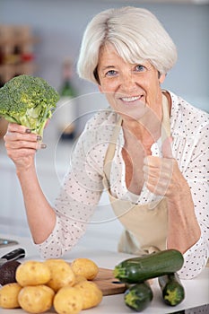 mature woman cooking vegetables in kitchen