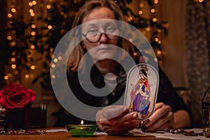 Mature woman defocused witch holding a fortune-telling card Lady.