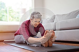 Mature woman doing yoga exercise at home photo