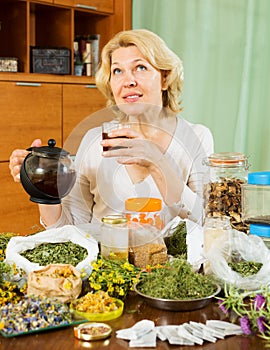 Mature woman with dried herbs brewing herbal tea